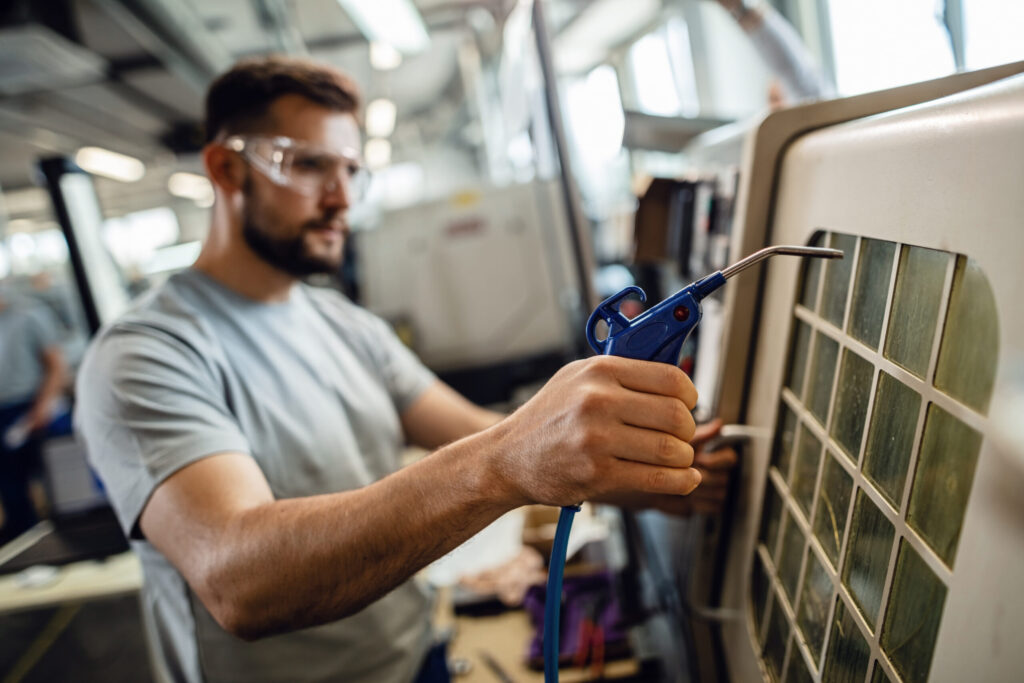 HVAC technician cleaning and maintaining AC ventilation filters as part of professional AC duct cleaning service in Dubai.
